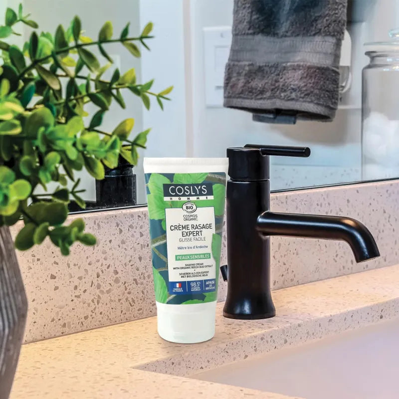 Une crème rasage expert certifiée bio 125ml coslys posée sur un meuble de salle de bain