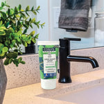 Une crème rasage expert certifiée bio 125ml coslys posée sur un meuble de salle de bain