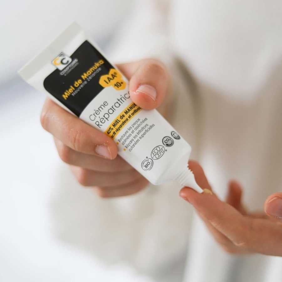 Zoom sur une personne en train d'appliquer sur son doigt de la crème réparatrice au miel de manuka de la marque Comptoirs et compagnies