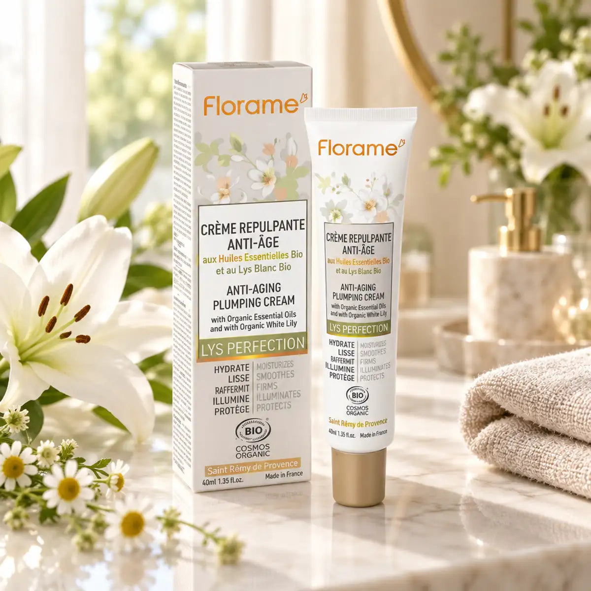 Crème Repulpante Anti-Âge Bio Florame 40 ml, pot et tube sur une coiffeuse en marbre, entourés de lys blancs et de camomille