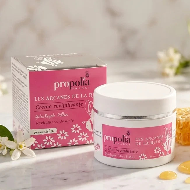Crème Revitalisante Les Arcanes de la Reine Propolia 50ml sur marbre avec miel et fleurs