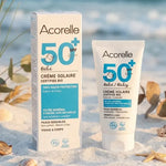 Crème solaire bébé SPF 50 bio Acorelle 50ml sur plage avec coquillages