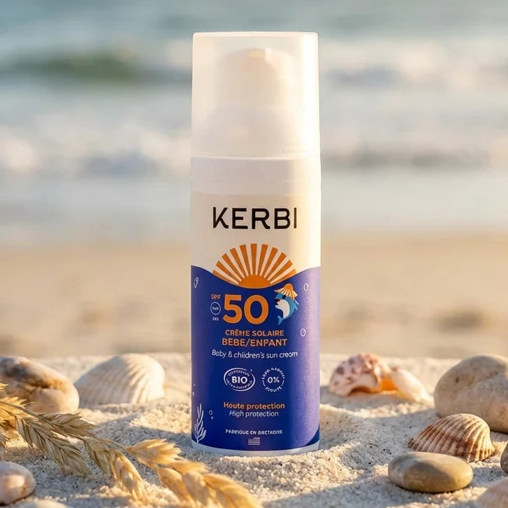 Crème solaire SPF 50 Kerbi pour bébé et enfant sur plage avec coquillages