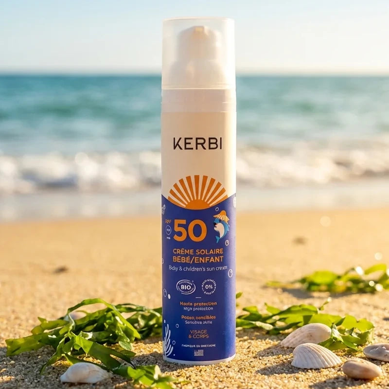 Crème solaire Kerbi SPF 50 sans parfum pour bébé sur plage avec coquillages