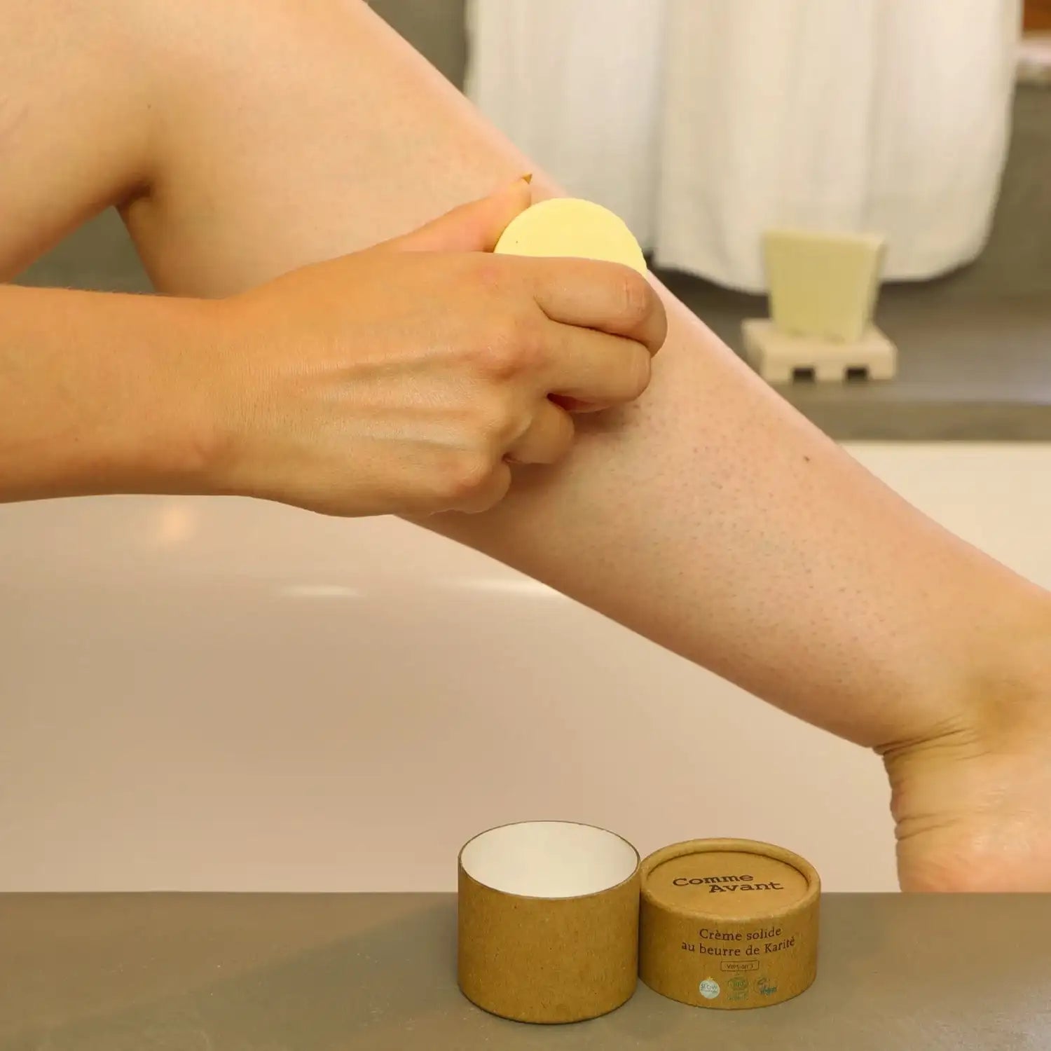 Zoom sur une femme en train de s'appliquer de la Crème Solide au Beurre de Karité Comme Avant sur la jambe