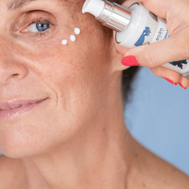 Une femme appliquant de la cème anti-âge de la marque Endro