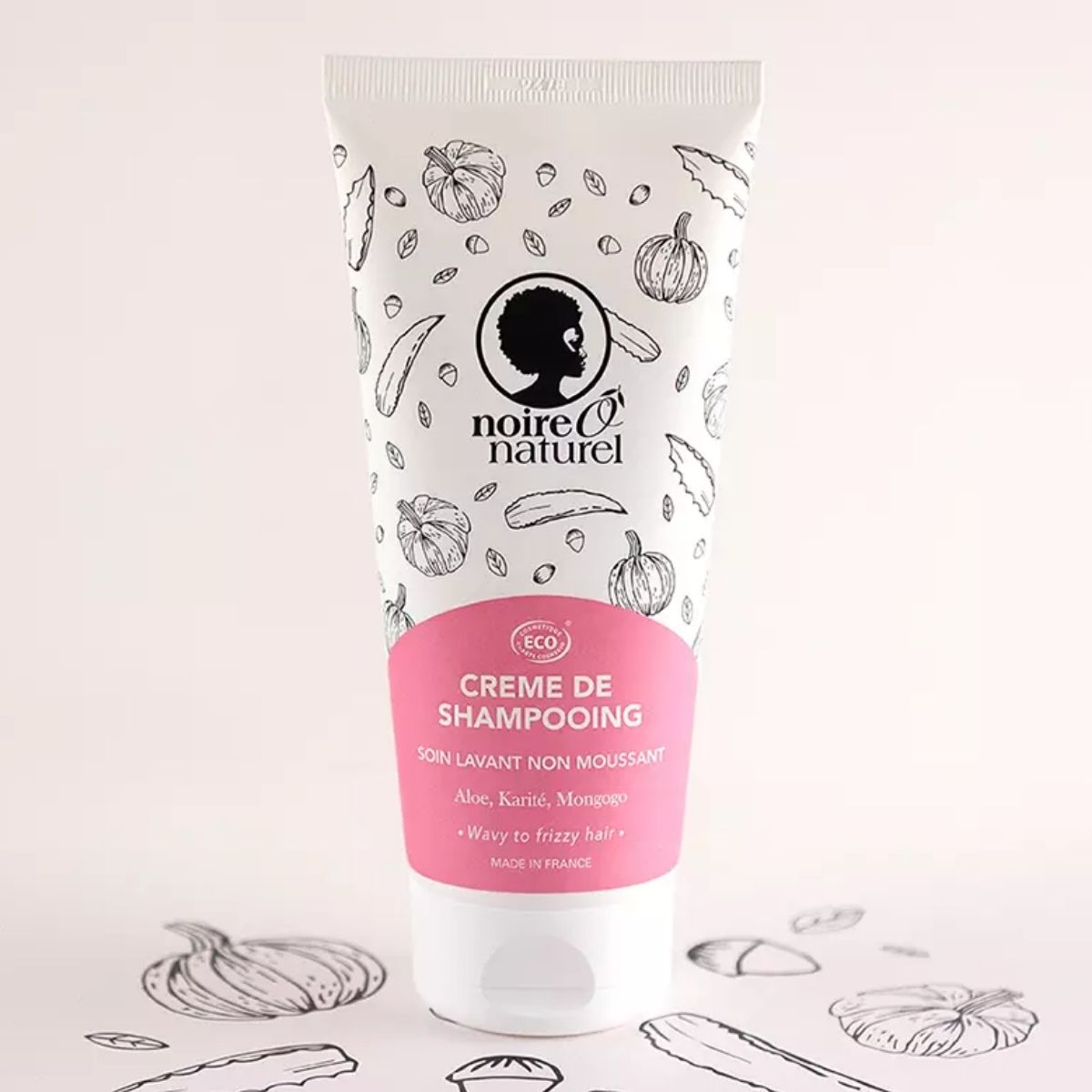 Crème de Shampooing Démêlante Noire Ô Naturel 200ml  sur fond rose.
