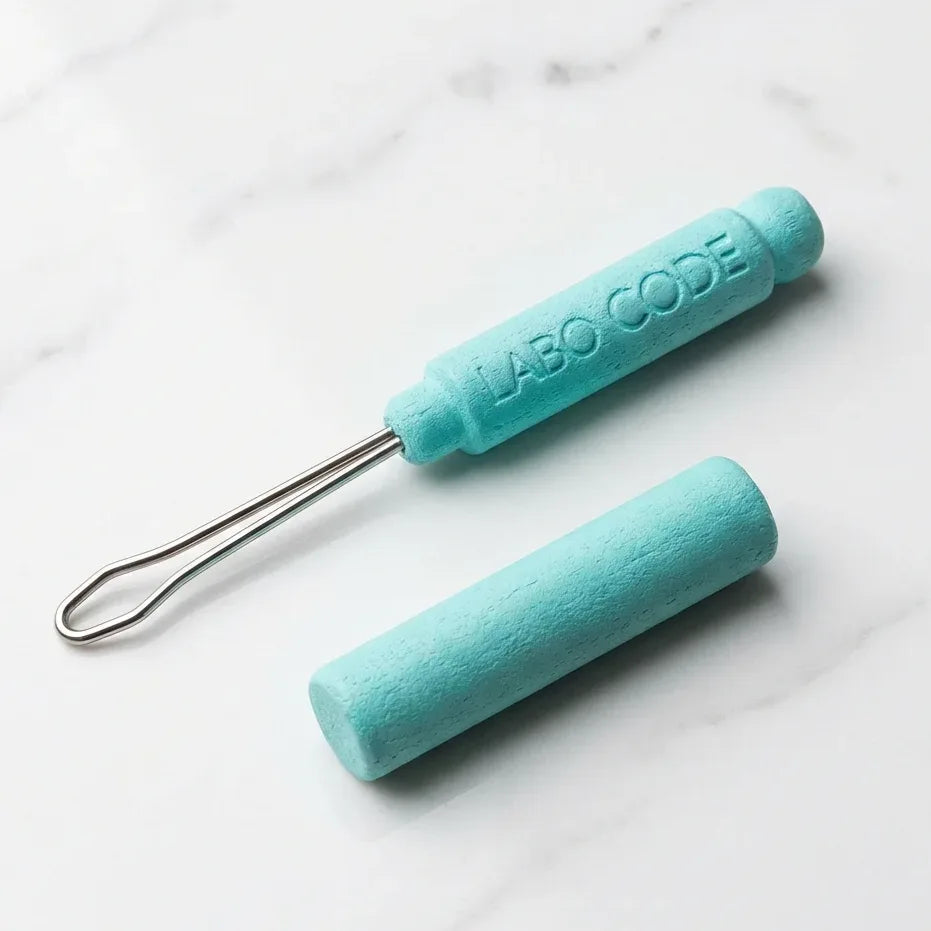 Cure oreille Laboratoire Code turquoise sur surface marbre minimaliste, design français premium