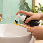 Dentifrice poudre menthe fraîche Pimpant appliqué sur brosse bambou au-dessus d'un lavabo blanc