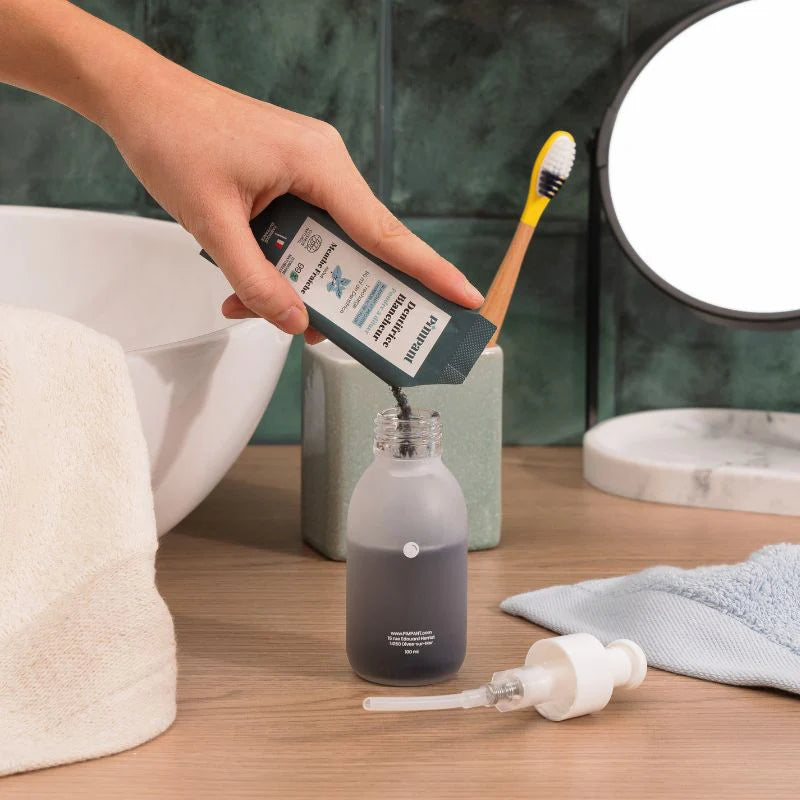 Recharge de dentifrice blancheur en poudre à la menthe fraîche de la marque Pimpant versée dans un flacon en verre 