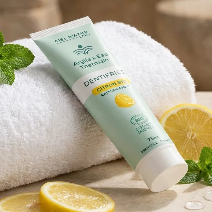 Dentifrice bio citron 75ml avec argile et eau thermale sur fond spa avec citrons frais