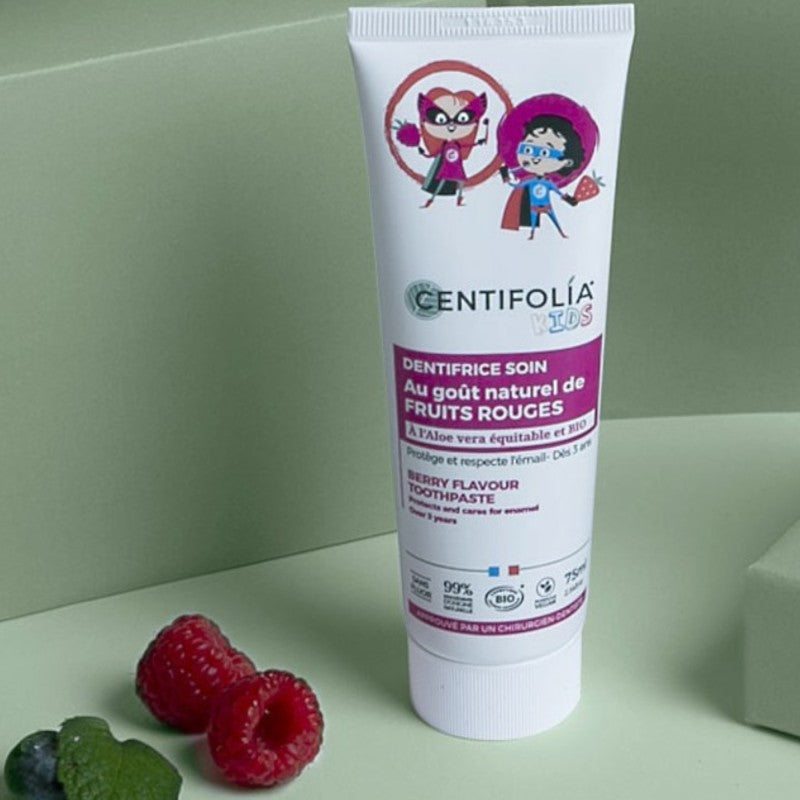 Un dentifrice aux fruits rouges de 75ml pour enfants de la marque Centifolia posé à côté de deux framboises