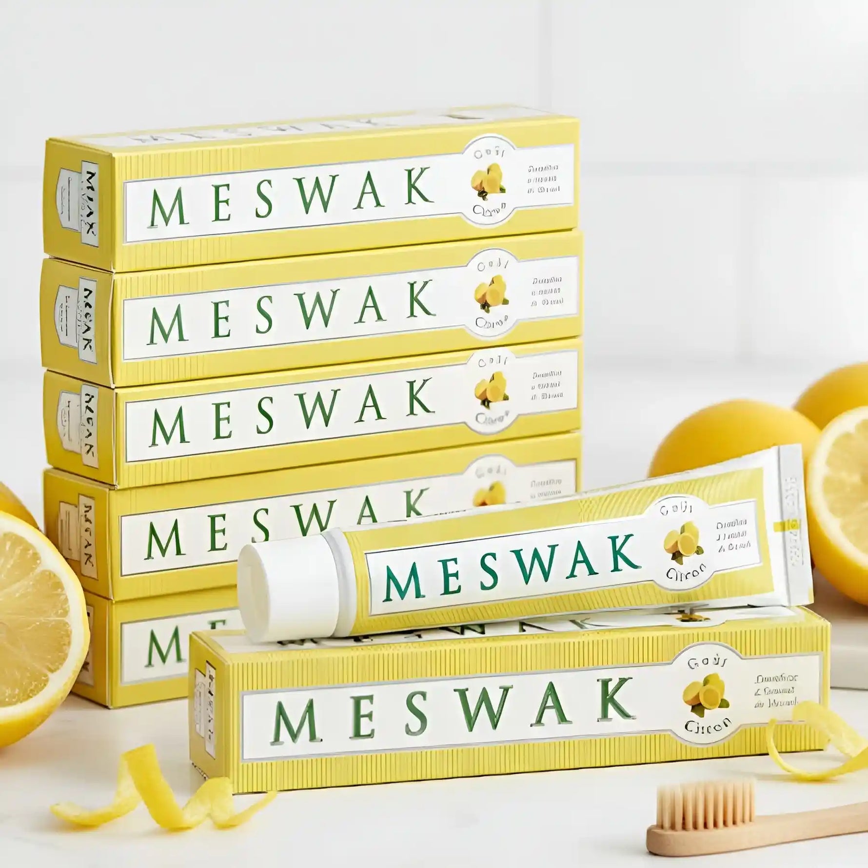 Un tube de Dentifrice Meswak ayurvédique goût citron posé à côté d'une rondelle de citron