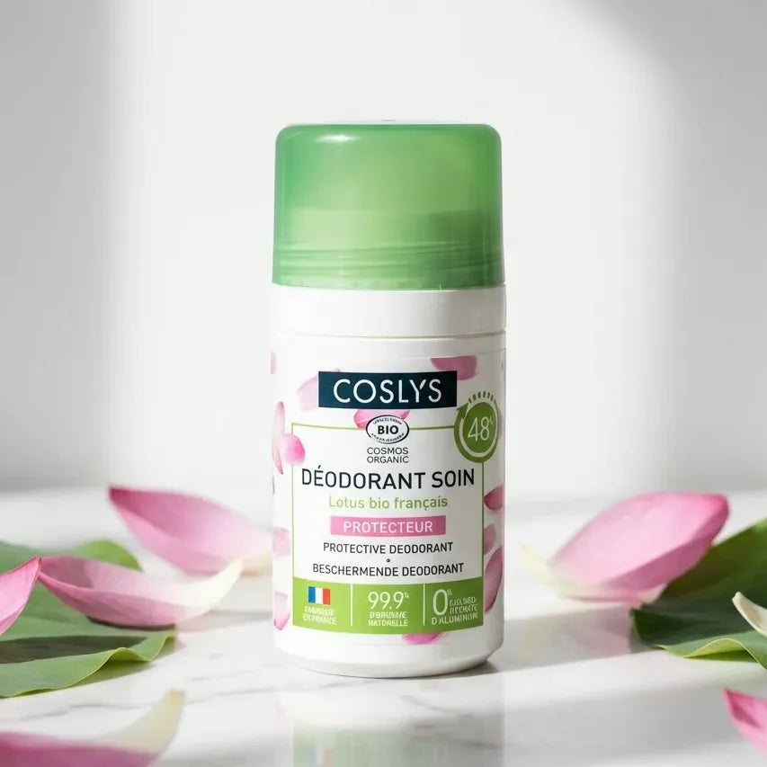 Déodorant Coslys bio Lotus 50ml sur marbre blanc avec pétales roses