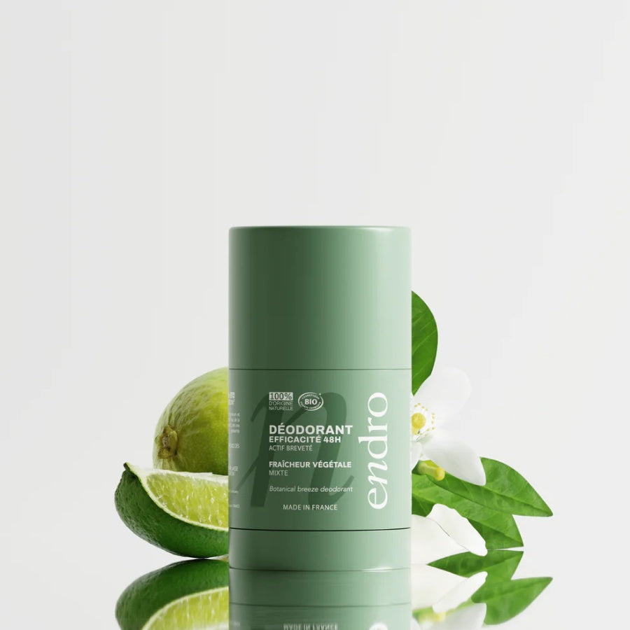 Déodorant stick Endro Fraîcheur Végétale entouré de citron vert et de feuilles, pour évoquer une senteur fraîche et végétale.