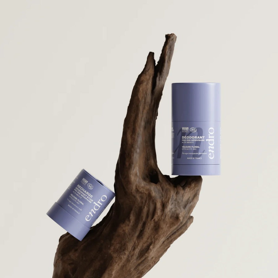 Déodorant stick Endro Pro-âge Ménopause posé sur une branche de bois, pour illustrer son univers naturel.