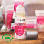 Un déodorant Bio roll-on Miel, Hamamélis & Cristal d'Alun de la marque Propolia posé sur une table en bois