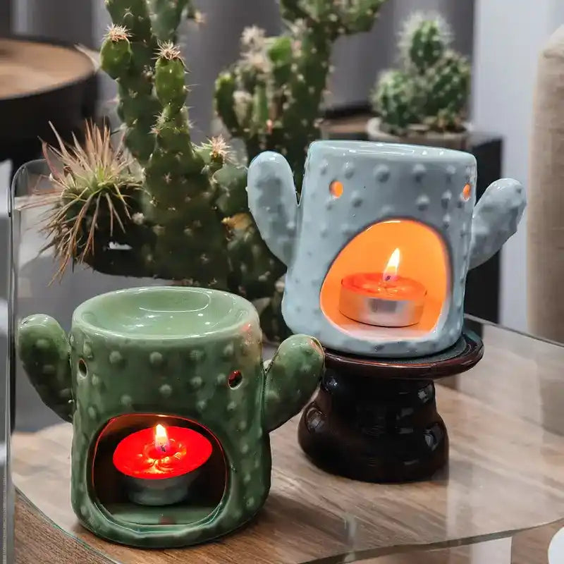 Deux brûleurs d'Huile Essentielle & Cire en céramique Cactus vert et bleu côte à côte, vue de face avec une bougie chauffe-plat allumée dedans