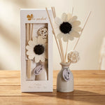 Diffuseur de parfum bâtonnets décoratif blanc avec fleur sur surface bois