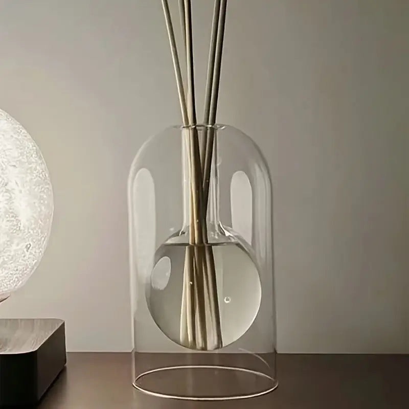 Un diffuseur de parfum en verre soufflé sur une table en bois