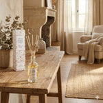 Un diffuseur de parfum à batonnets senteur Jardin du Levant de la marque Jardin de Mon Grand Père, posé sur une table enbois