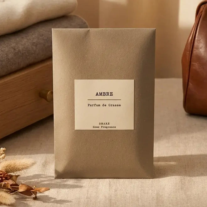 Enveloppe Parfumée Ambre Parfum de Grasse DRAKE sur linge beige avec accessoires luxe