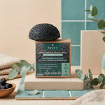Éponge Konjac Bio Kyuké au charbon actif sur son emballage en cadre minimaliste spa