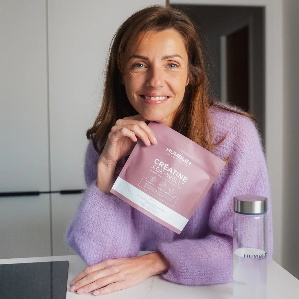 Femme qui tient la Créatine Glow AGE-WELL 300g Humble+ dans une main