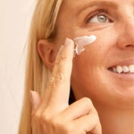 Une femme blonde appliquant de la crème sur le visage