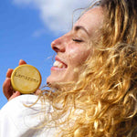 Femme qui tient le shampoing cheveux blonds Lamazuna en souriant