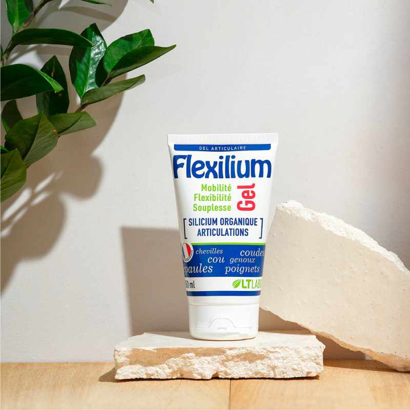 Un tube de 150ml de Flexilium gel de la marque LT Labo mis en scène à côté d'une plante verte