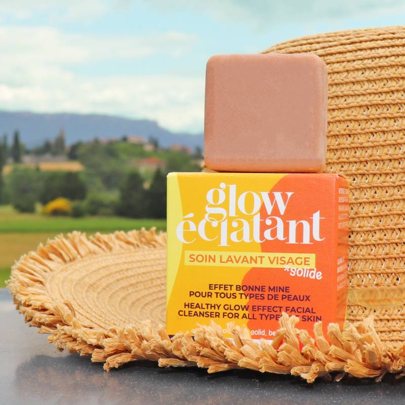 Soin lavant visage solide glow eclatant de la marque Lamazuna posé sur un chapeau de paille