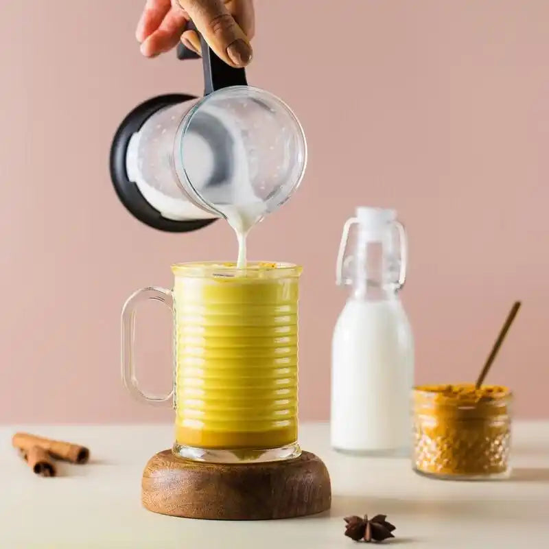 Préparation d'un golden latte avec du lait qui coule dans une tasse
