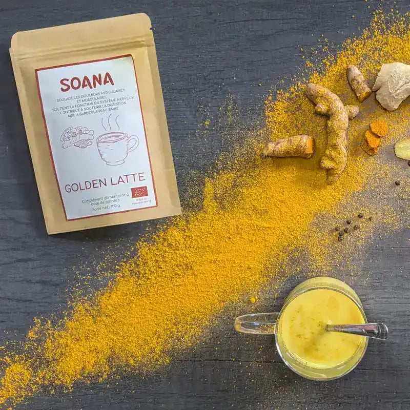 Sachet de 100 g de golden latte de la marque Soana sur un lit d'epices de curcuma et de gingembre