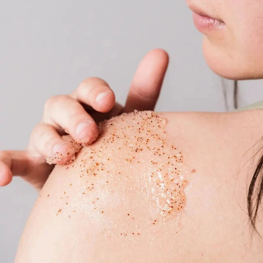 Une femme en train d'appliquer un gommage sur l'épaule