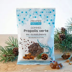 Gommes Propolis Verte bio Propos'Nature avec branches de pin et miel sur bureau en bois