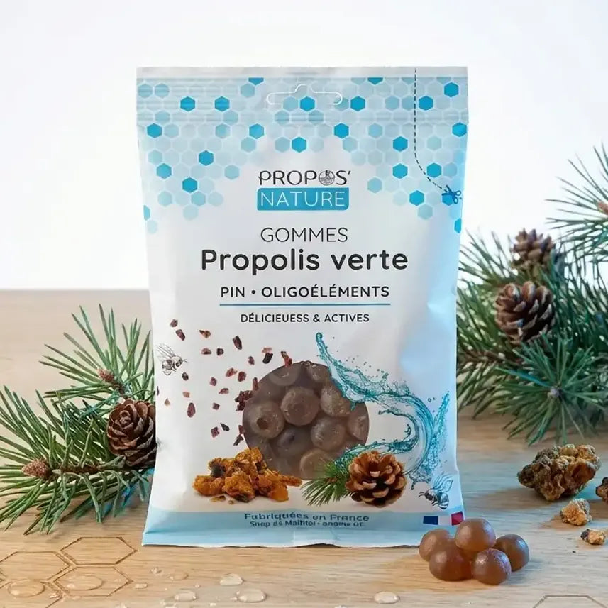 Gommes Propolis Verte bio Propos'Nature avec branches de pin et miel sur bureau en bois