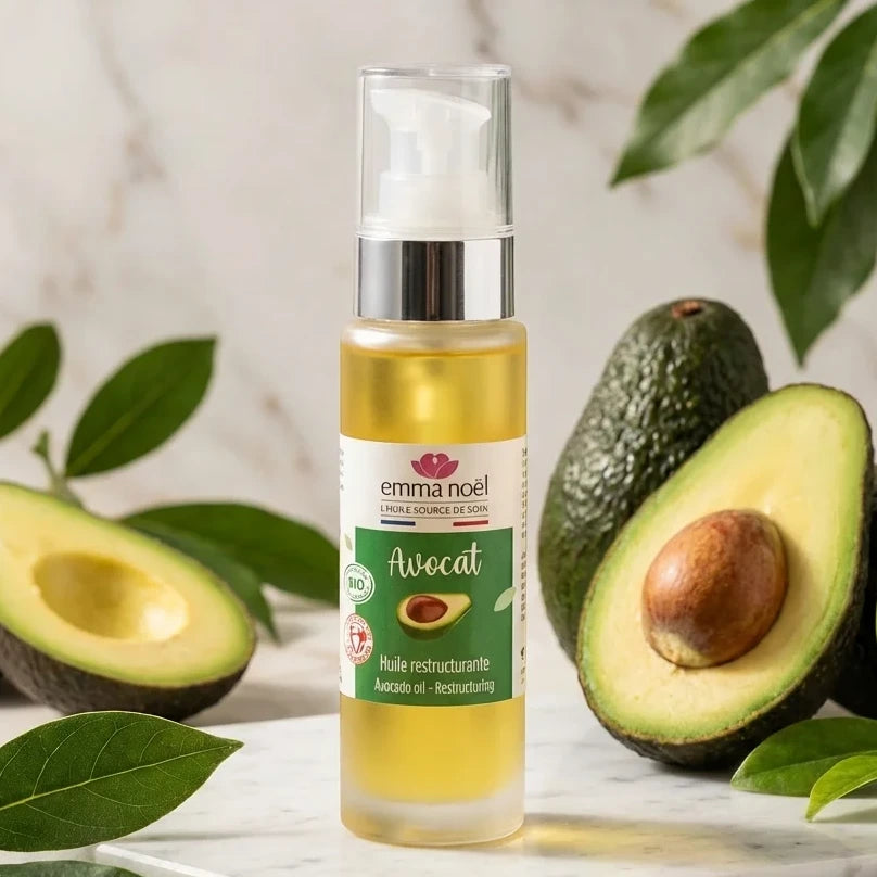 Huile d'avocat bio Emma Noël 50mL avec avocats frais sur surface marbre
