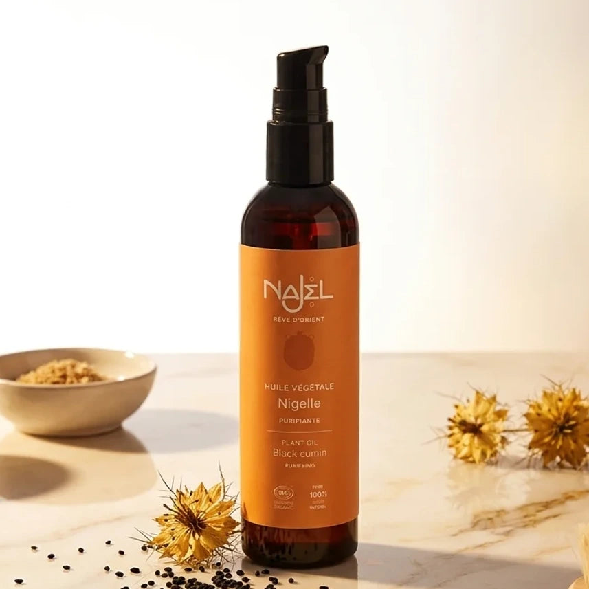 Huile de Nigelle Bio Najel 125ml avec graines de nigelle et fleurs séchées sur fond blanc