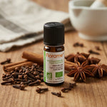 Flacon d'huile essentielle de clou de girofle bio Florame 10ml entouré d'épices
