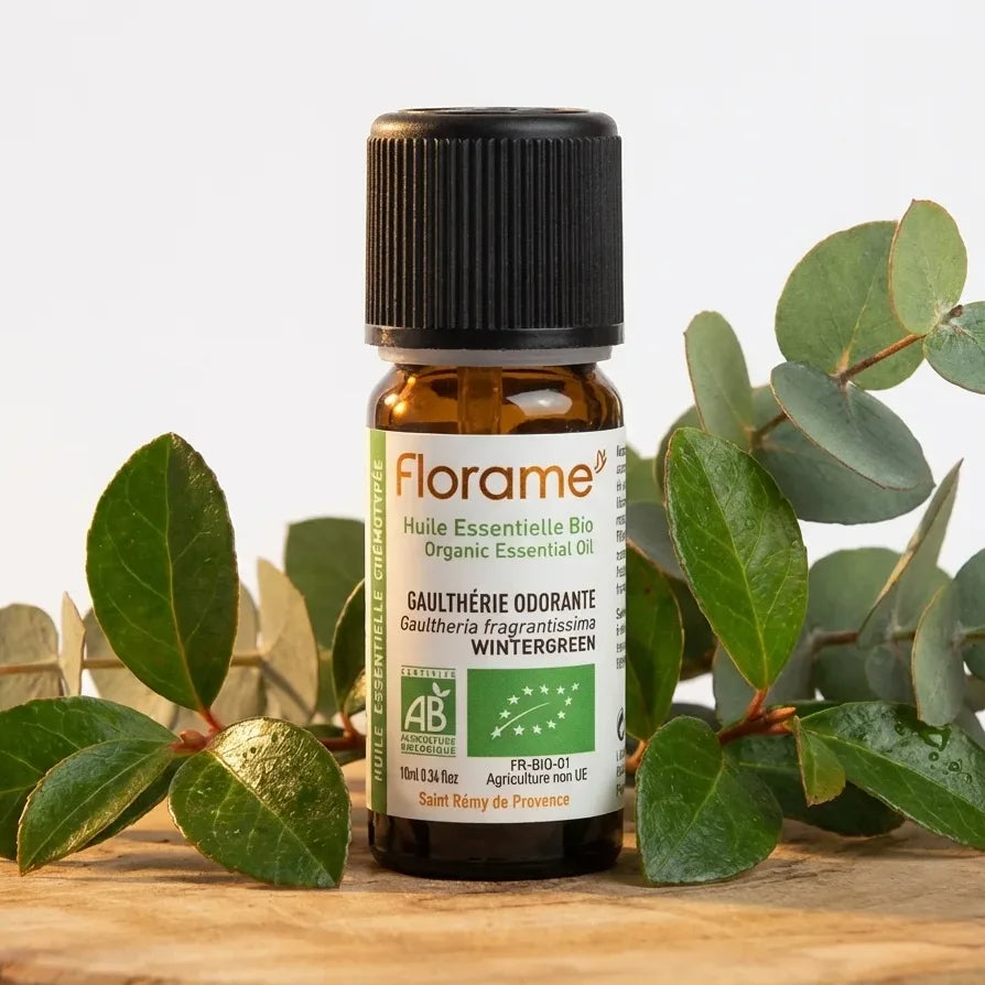 Huile essentielle Gaulthérie Florame 10ml bio avec feuilles fraîches sur bois naturel
