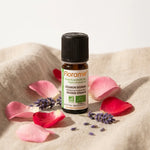 Flacon huile essentielle géranium bourbon bio Florame 5ml entouré de pétales roses et lavande