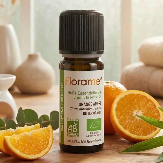 Huile essentielle d'orange amère bio Florame 10ml avec tranches d'orange fraîches et décor zen