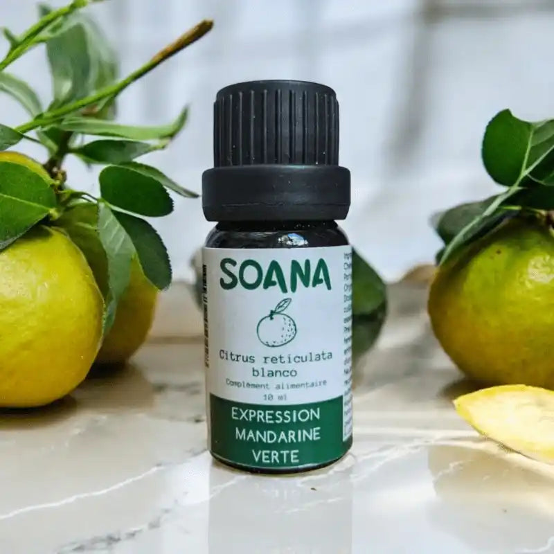 Flacon de 10 ml d'huile essentielle de Mandarine verte de la marque Soana sur fond blanc et avec mandarines vertes 