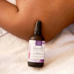 Une huile de massage sensualité de la marque comptoir des huiles en 100 ml  posée sur une épaule