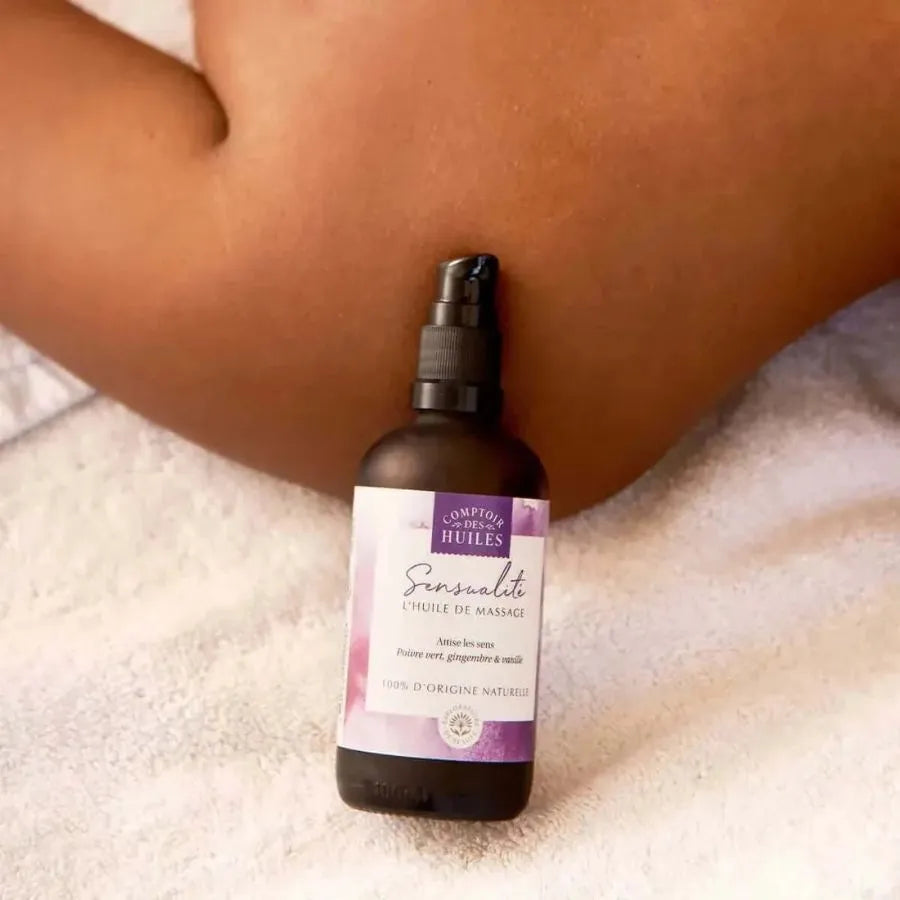 Une huile de massage sensualité de la marque comptoir des huiles en 100 ml  posée sur une épaule