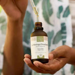 Une huile de moringa Drouhardii de la marque comptoir des huiles en 50 ml tenue dans les mains d'une femme