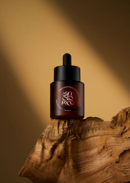 Huile pour peau grasse – 30 ml – Andromée, posée sur une bout de bois