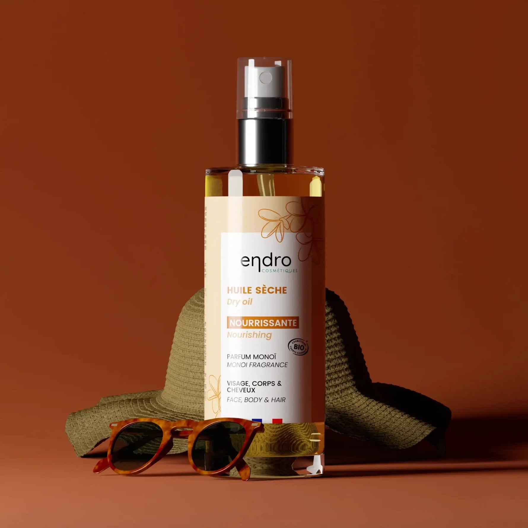 Un flacon d'Huile sèche Visage, Corps & Cheveux Bio Endro sur fond ocre