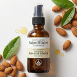 Huile d'Amande Douce Bio Saint-Hilaire 50ml entourée d'amandes brutes et feuilles vertes